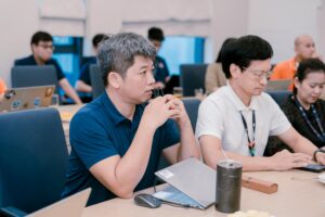 Engaged professionals in a corporate meeting room discussing ideas with laptops and notes.
