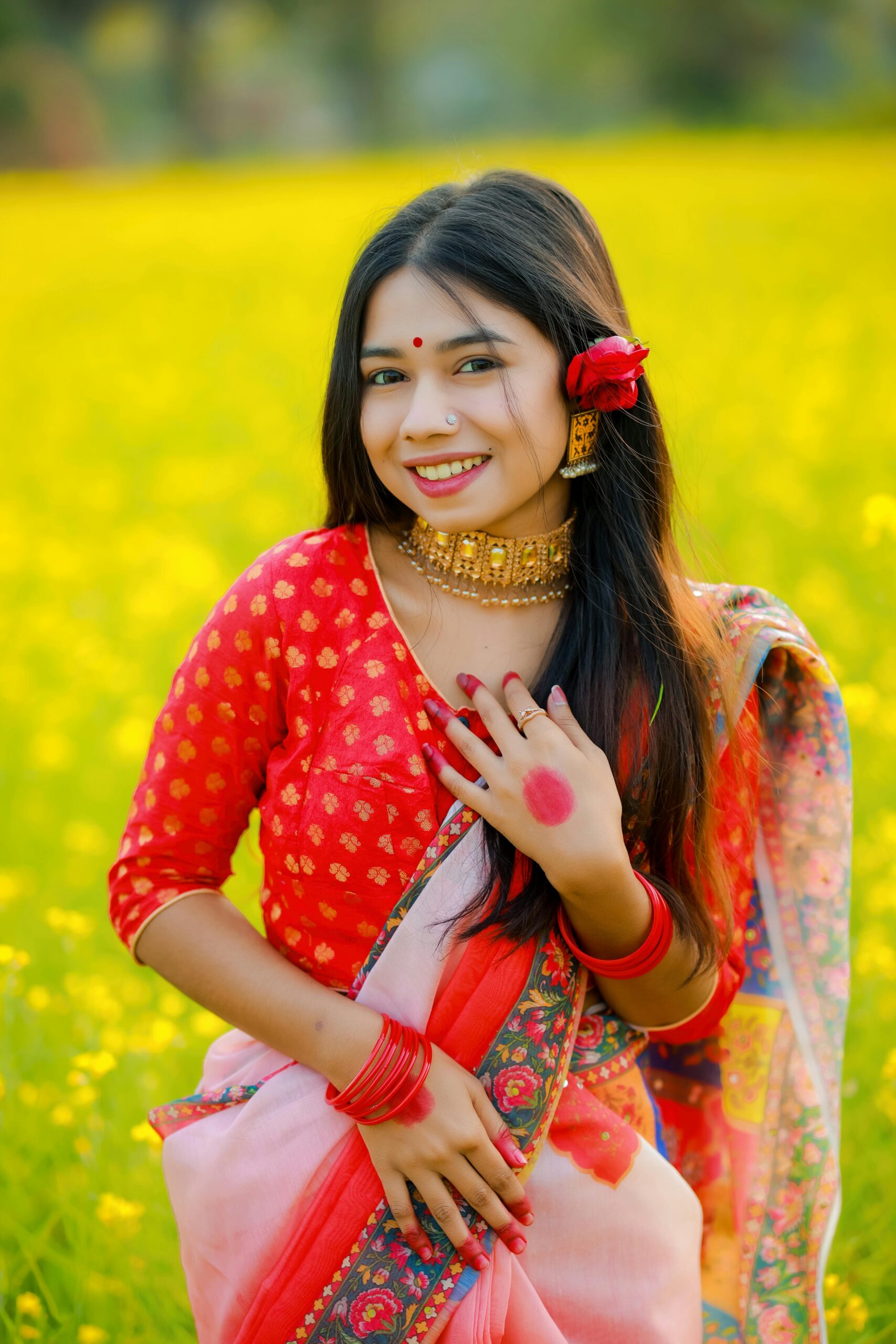 A South Asian woman in vibrant traditional attire posing in a lush flower field. Perfect for cultural and lifestyle themes.